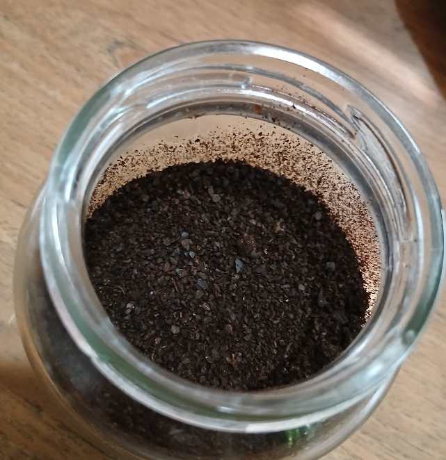 乾燥させたコーヒーかすをガラス瓶に入れる